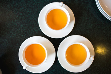 Obraz na płótnie Canvas top view of three cups with fresh herbal tea
