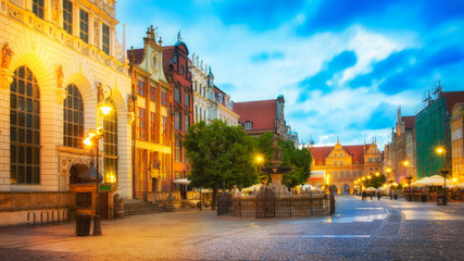 Fototapeta na wymiar Beautifully illuminated Old Town in Gdansk with Neptune's statue. Poland, Pomerania.