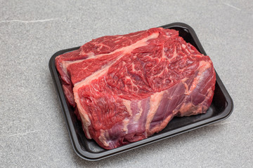 steak fat beef  with white plate and old wooden board