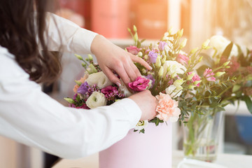 Woman florist making a beautiful flower composition in a flower shop