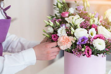 Woman florist making a beautiful flower composition in a flower shop
