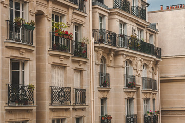 Beautiful details of typical buildings of Paris with forged iron balcony railings and flowers