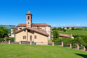 Fototapeta na wymiar Small parish church on green lawn in Italy.