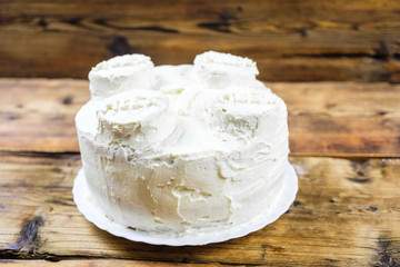 Homemade birthday's white cake for 7 year-old boy Round cake in the shape of brick. Side view