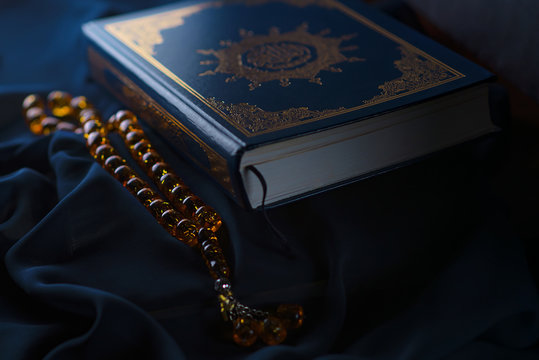 Holy islamic book Koran on the draped table with a rosary. Ramadan Kareem beautiful poster, banner, postcard for the celebration of the festival of the Muslim community