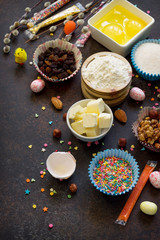 Ingredients for Easter baking - eggs, nuts, flour, yeast, butter, raisins, sugar and willow branches. Seasonal, food background.