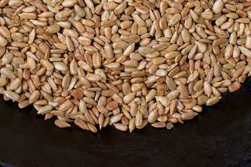 Roasted sunflower seeds in a black skillet