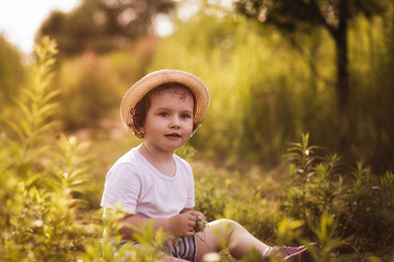 little girl is playing on nature in summer
