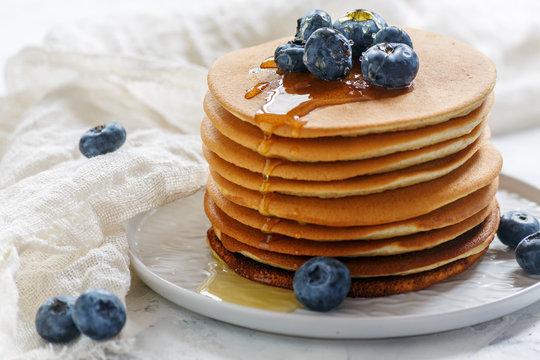 Stack of pancakes with honey and blueberry.