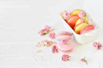 Dessert: A Delicate Fresh French Macaroons In Pastel Colors Gift Box With Flowers Roses On A Light Textile Background