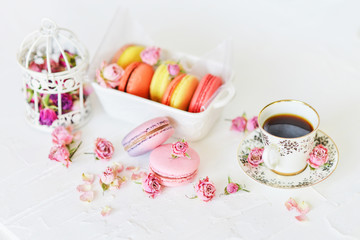 Dessert: A Delicate Fresh Colorful French Macaroons In Pastel Colors With Flowers Roses On A Light Textile Background, Top View