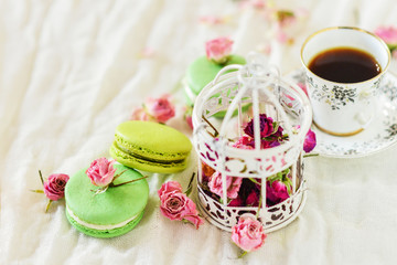 Dessert: A Delicate Fresh Colorful French Macaroons In Pastel Colors With Flowers Roses On A Light Textile Background, Top View