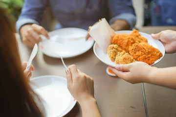 close up waitress holding dish of fried chicken and snack serve to customer at outside restaurant shop in weekend , people lifestyle concept