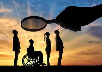 Employer's hand looks through the magnifying glass to an invalid in a wheelchair waiting for an...