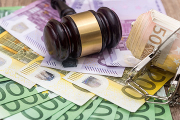 Handcuffs and euro bills and wooden gavel as crime concept