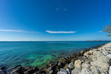 USA, Florida, Blue clean clear ocean water at key west behind white rocks