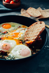 fried eggs with spinach, tomatoes and toasted bread.