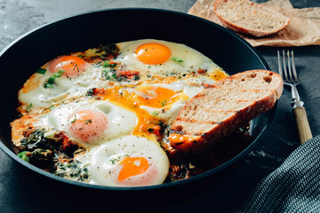 fried eggs with spinach, tomatoes and toasted bread.