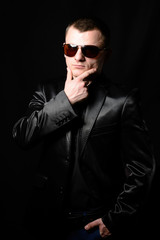 Obraz premium Studio portrait of a young guy with a short haircut in brown sunglasses