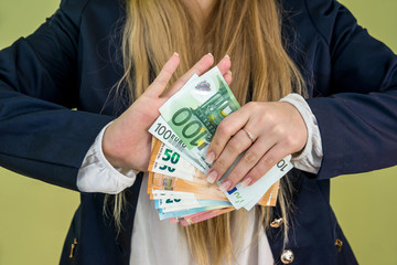 female holding euro in her hands isolated on green