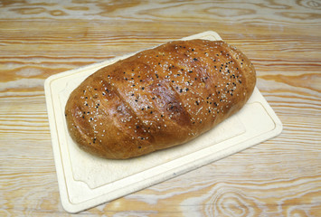 Freshly baked bread with sesame on a white plate. 