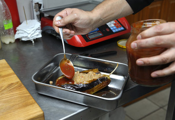 A cook in a restaurant kitchen preparing Tatar dish 