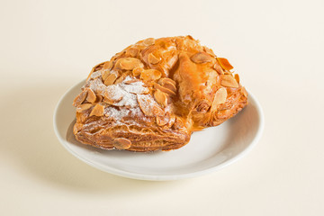 Bun with chocolate filling and peanut from puff pastry sprinkled with powdered sugar.