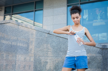 Woman runner is having break, drinking water