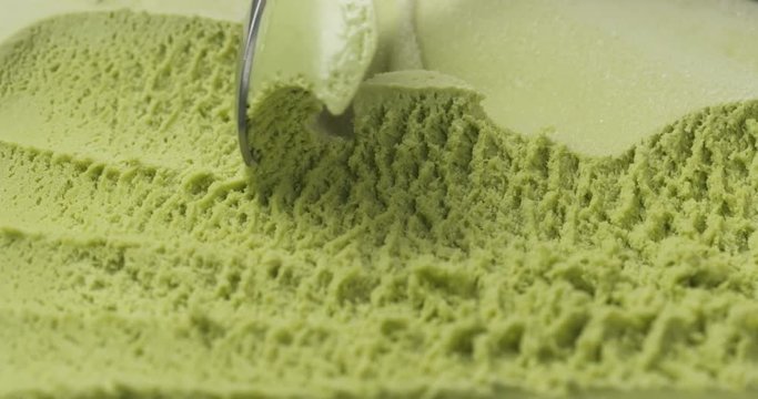 Slow motion closeup matcha ice cream scooping with spoon