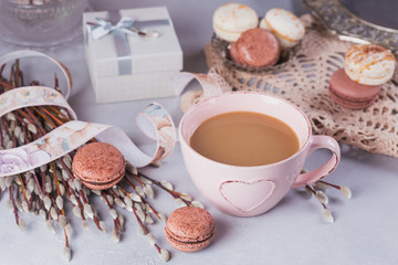 Pink coffee mug with sweet pastel french macaroons, gift box and pussy willow
