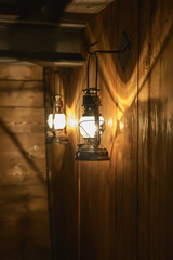 Beautiful light and shadows are reflected on the wooden wall from the old gas lamp.