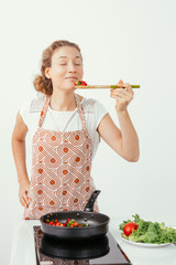 Pleased attractive housewife smelling food