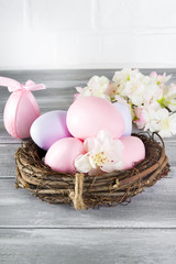 Easter eggs in nest on wooden background