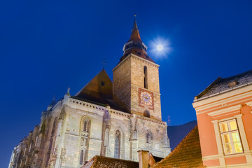 Fototapeta premium Night scene with the famous Black Church and the full moon on the sky in Brasov, Romania