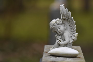 Fototapeta na wymiar An angel and a heart of stone on a tombstone