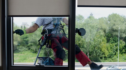 Window washer is cleaning high office building