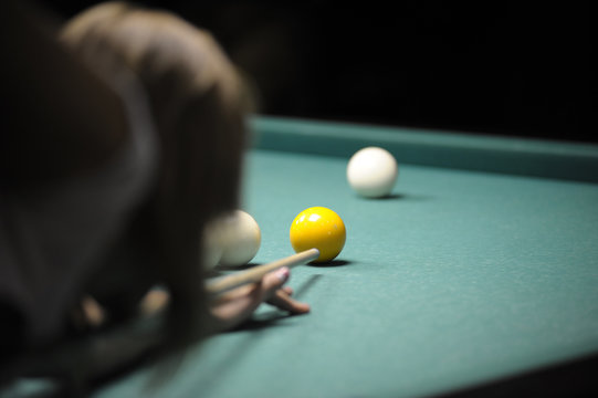 Billiard: a pool player gets ready to stroke a ball with a cue