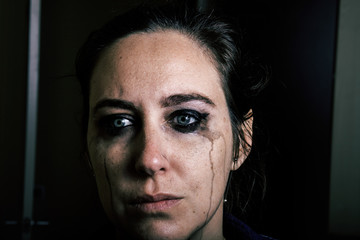 Woman crying with light eyes with blurred makeup gender