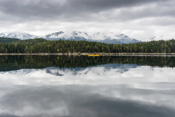 Einsames Kajak im Herbst auf einem See vor Bergen