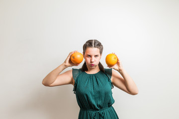 Young woman makes expressions with grapefruits