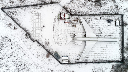 The plane is parked in the forest in winter