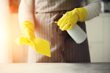 Woman in yellow rubber protective gloves wiping dust and dirty. Cleaning concept, banner, copy space