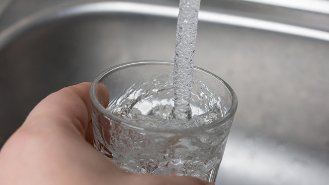 Wasser in ein Glas eingie&szlig;en