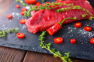Composition with meat, pepper and spicies on a rustic kitchen.