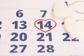 14th February marked with a heart on calendar and wooden hearts. Close up. St.Valentine's concept.