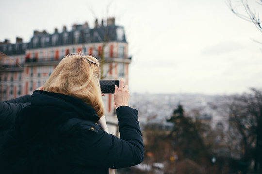 Donna bionda fotografa con smartphone dall'alto