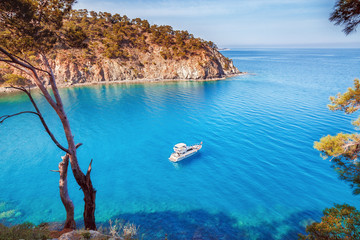 Fototapeta premium Malownicza sceneria wybrzeża Turcji na Morzu Śródziemnym. Samotny luksusowy biały jacht w niesamowitej zatoce. Tło wakacje letnie. Lokalizacja Antalya Turcja.