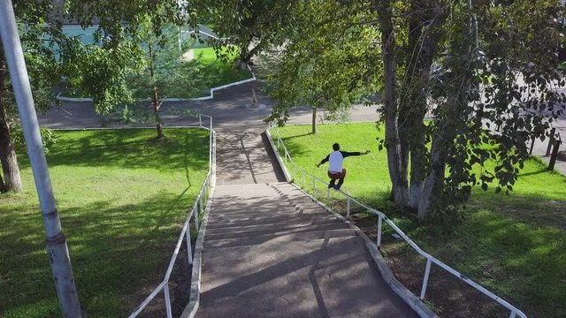Aggressive inline roller blader grind on rail in skatepark outside. Clip. Summer extreme sport exercising outdoor in skate park. Skater guy grinding on railing in park. Cool activity hobby for young