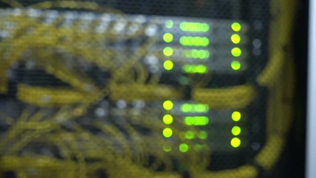 Rack Mounted Servers In A Server Room, Server rack audio cable. Severs computer in a rack at the large data center. Fiber Optical connector interface. Flashing lights blurred background