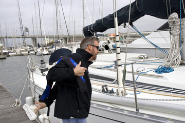 Charleston Marina South Carolina, February 17, 2018 - man struggling to put on lifejacket next to...